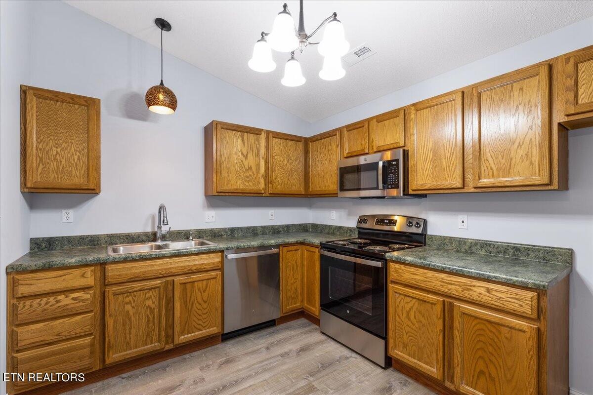 731 High Point Way, Knoxville, TN 37912 - Photo 12 of 25 a kitchen with stainless steel appliances granite countertop a sink a stove microwave and cabinets