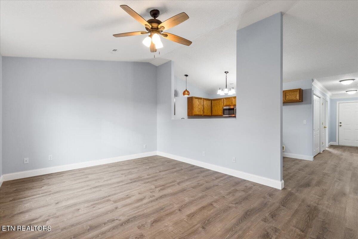 731 High Point Way, Knoxville, TN 37912 - Photo 18 of 25 a view of an empty room with wooden floor and a ceiling fan