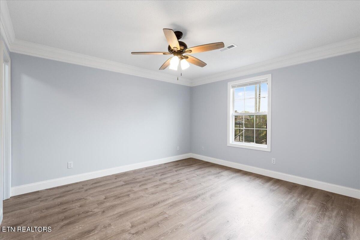 731 High Point Way, Knoxville, TN 37912 - Photo 19 of 25 an empty room with wooden floor fan and windows