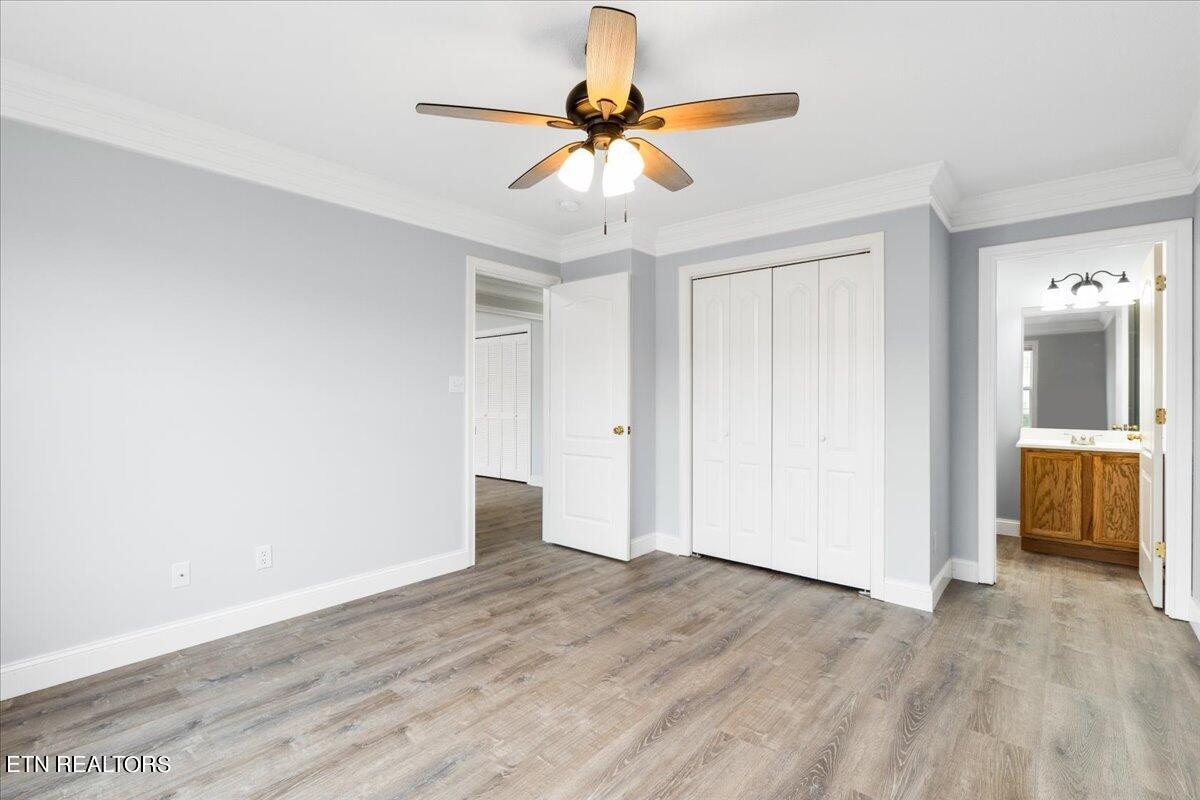 731 High Point Way, Knoxville, TN 37912 - Photo 6 of 25 a view of an empty room with wooden floor and a ceiling fan
