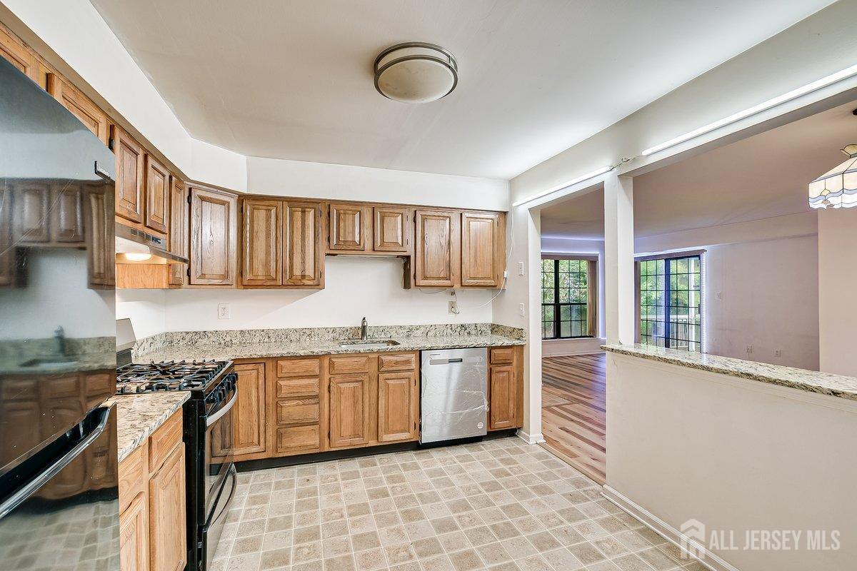 5001 Stonehedge Road Edison, NJ 08820 - Photo 12 of 22 a kitchen with stainless steel appliances granite countertop a stove sink and cabinets