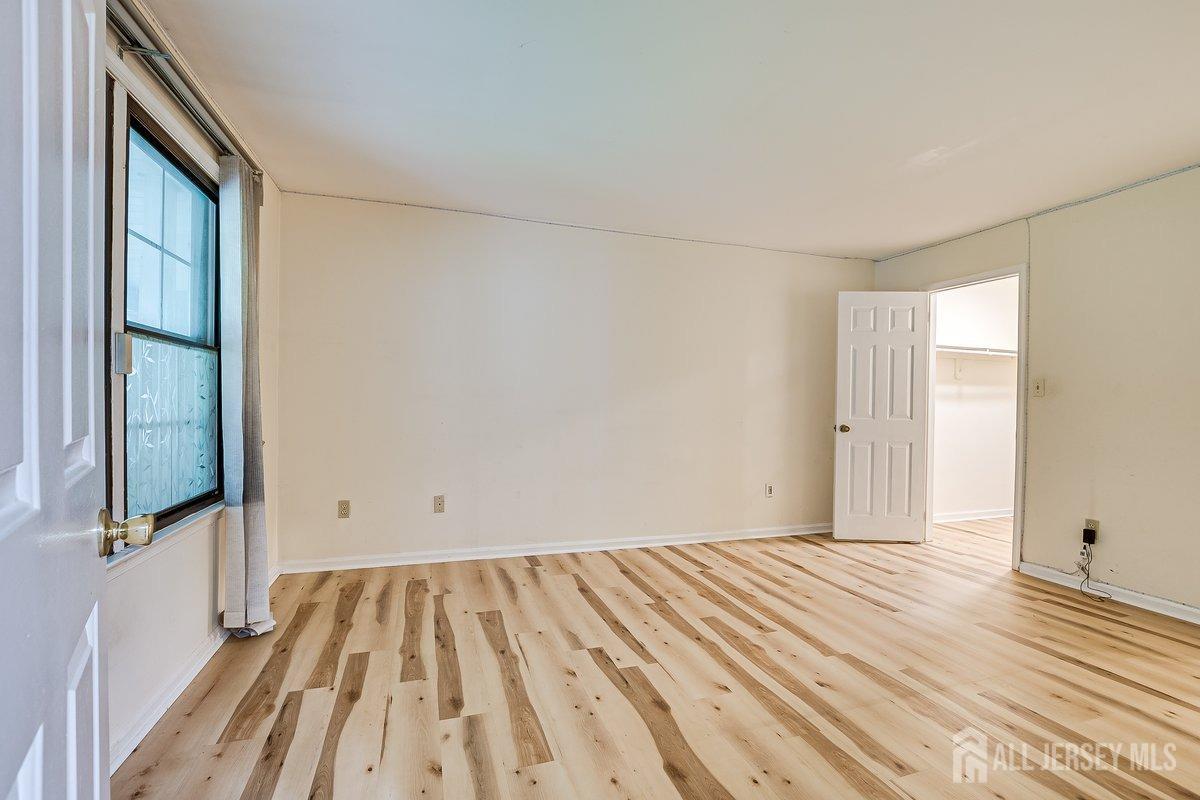 5001 Stonehedge Road Edison, NJ 08820 - Photo 14 of 22 a view of a room with wooden floor and a window