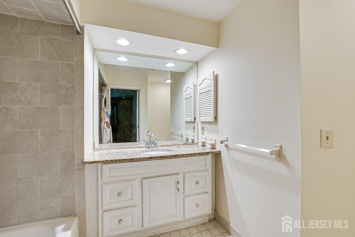 5001 Stonehedge Road Edison, NJ 08820 - Photo 17 of 22 a bathroom with a double vanity sink and mirror
