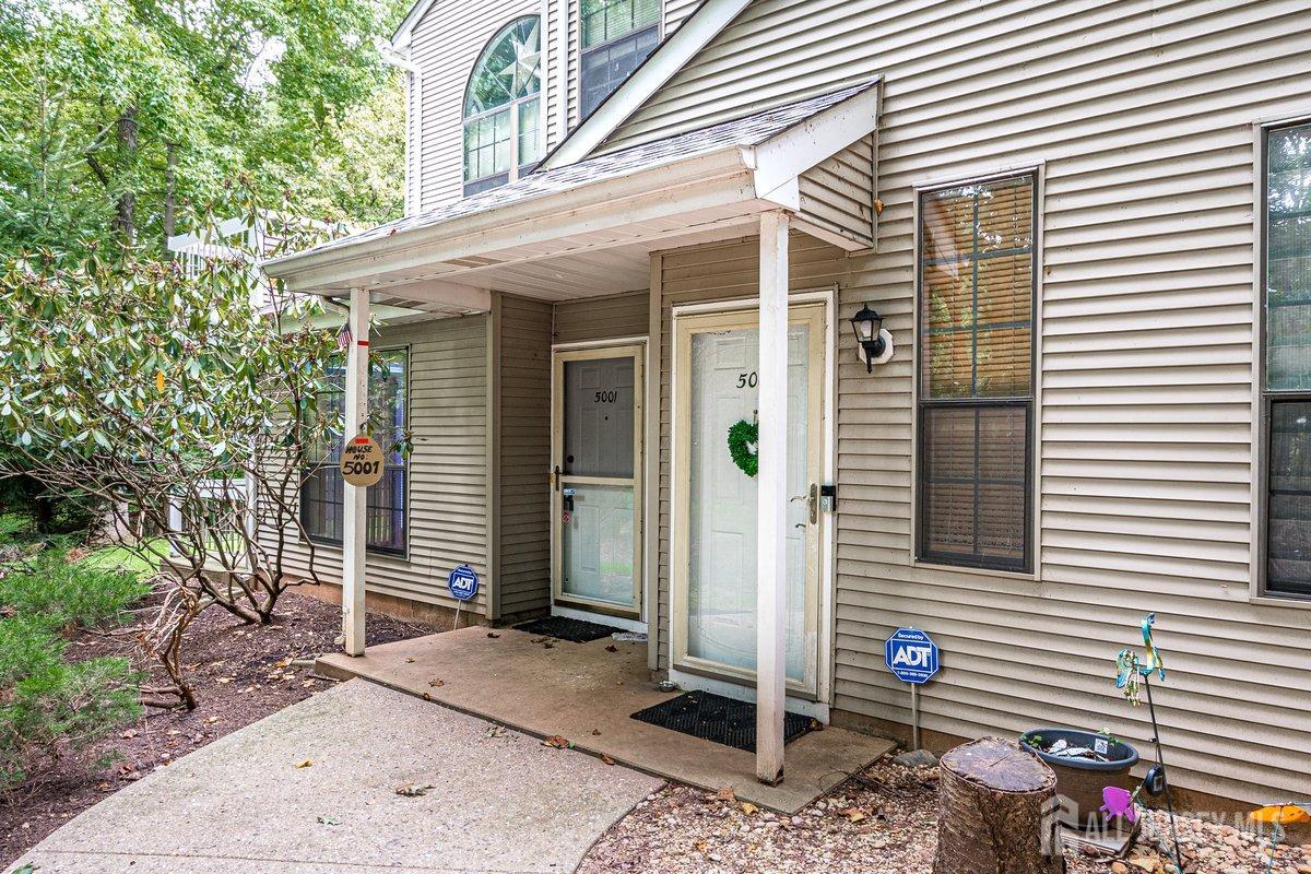 5001 Stonehedge Road Edison, NJ 08820 - Photo 4 of 22 a view of a porch with a table and chairs and potted plants