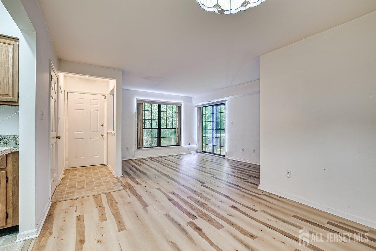 5001 Stonehedge Road Edison, NJ 08820 - Photo 6 of 22 a view of an empty room with wooden floor and a window