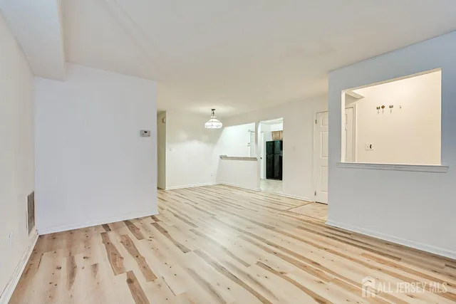 a view of empty room with wooden floor
