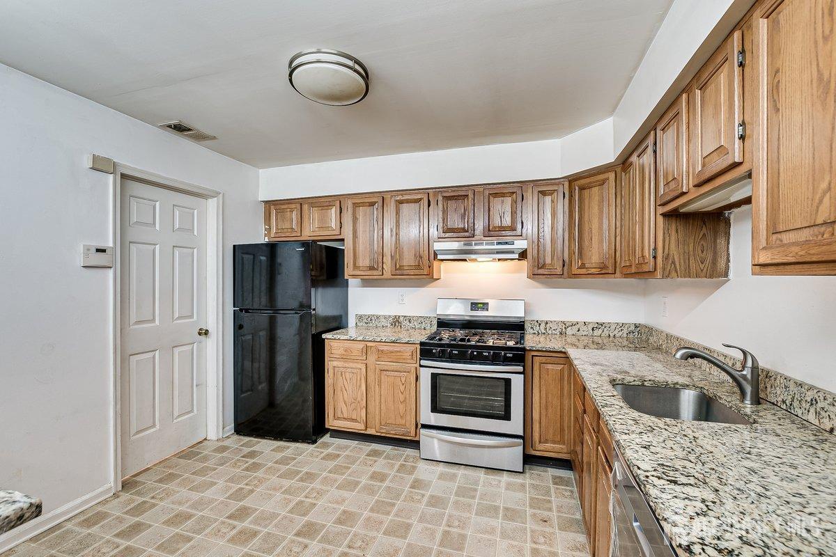 5001 Stonehedge Road Edison, NJ 08820 - Photo 10 of 22 a kitchen with stainless steel appliances granite countertop a stove a sink and a refrigerator