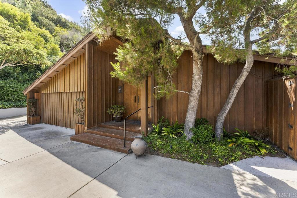 7675 Via Capri La Jolla, CA 92037 - Photo 11 of 75 a view of backyard with potted plants and a large tree