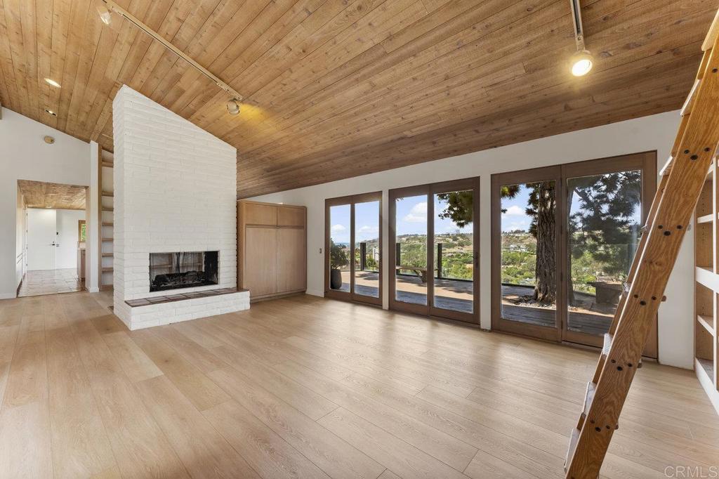 7675 Via Capri La Jolla, CA 92037 - Photo 16 of 75 a view of an empty room with wooden floor and a window