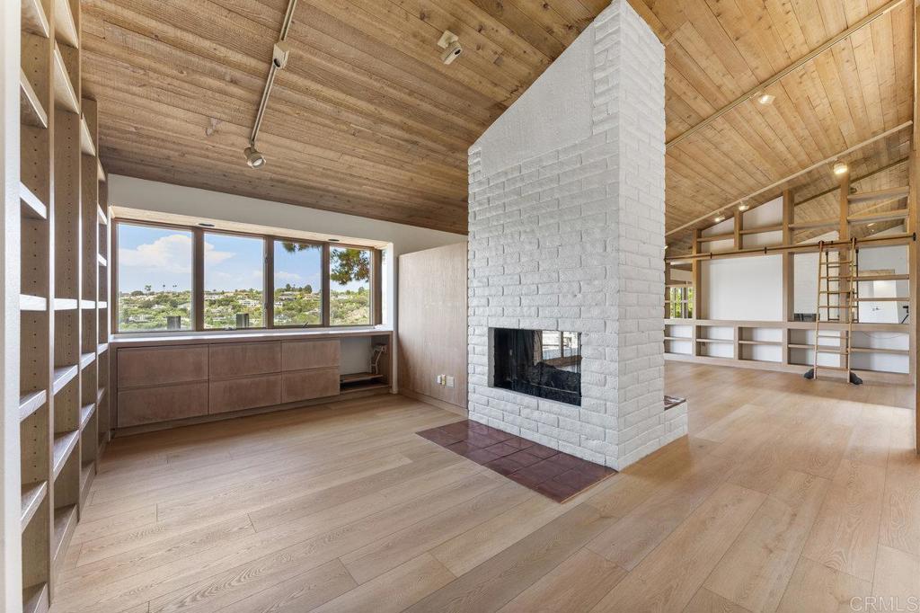 7675 Via Capri La Jolla, CA 92037 - Photo 18 of 75 a view of an empty room with a fireplace and a window