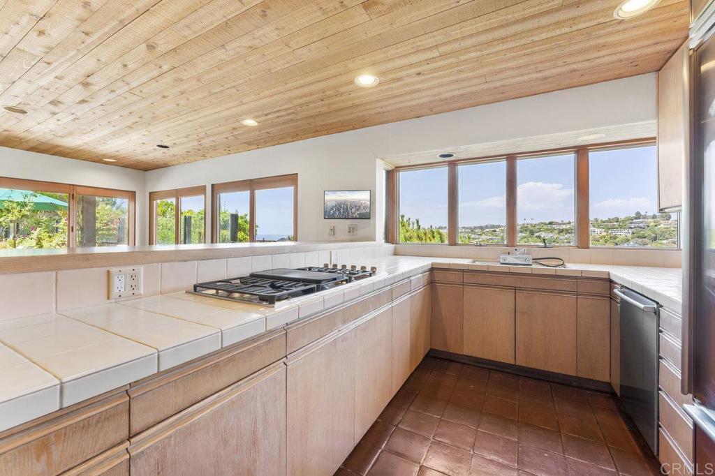 7675 Via Capri La Jolla, CA 92037 - Photo 20 of 75 a kitchen with a stove sink and cabinets