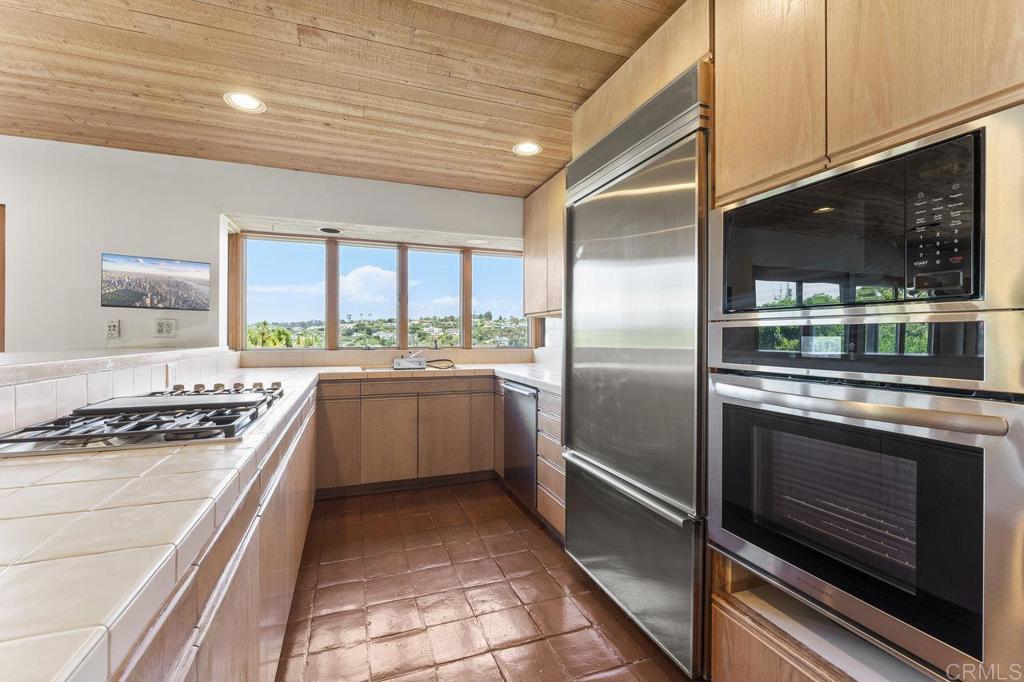 7675 Via Capri La Jolla, CA 92037 - Photo 21 of 75 a kitchen with a stove a sink and a refrigerator