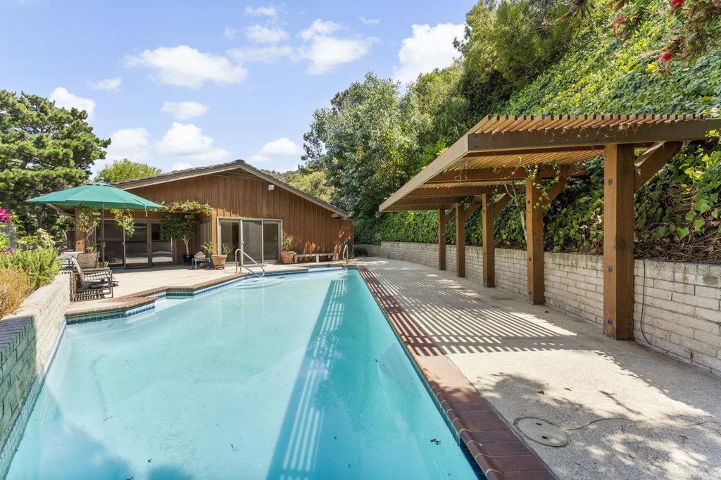 7675 Via Capri La Jolla, CA 92037 - Photo 43 of 75 a view of a patio with a table and chairs under an umbrella