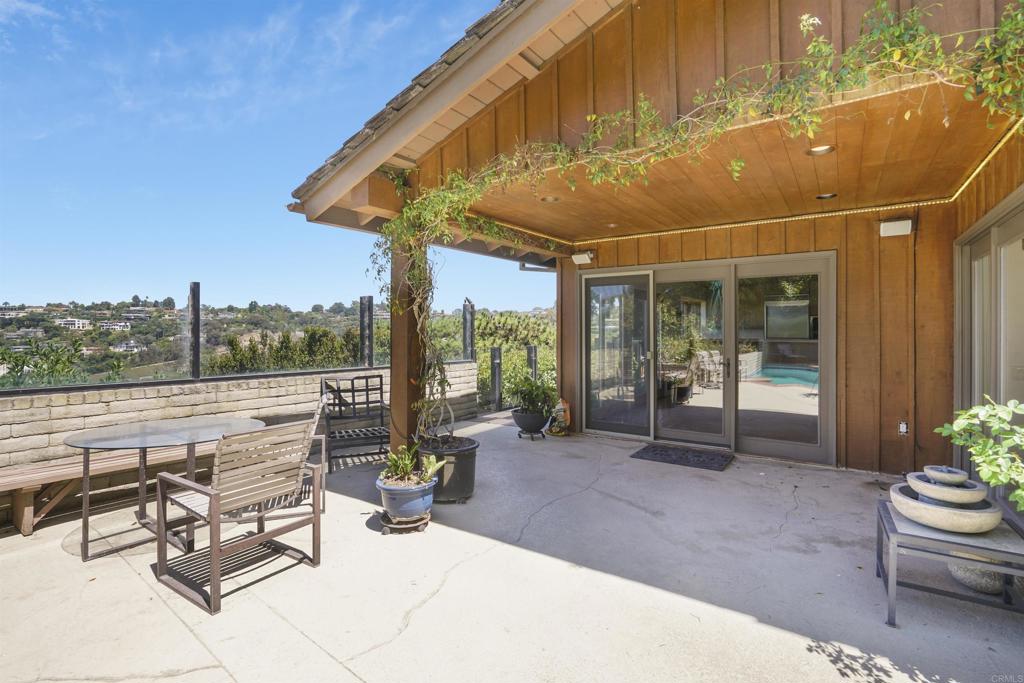 7675 Via Capri La Jolla, CA 92037 - Photo 53 of 75 a view of a patio with a table and chairs and floor to ceiling window