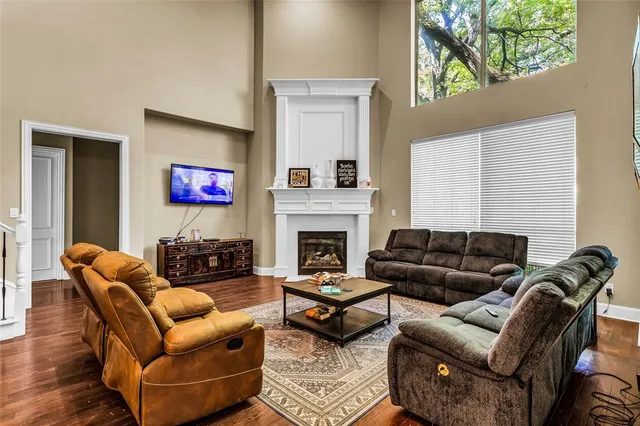 a living room with furniture a flat screen tv and a fireplace