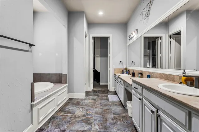 a bathroom with a tub sink and mirror