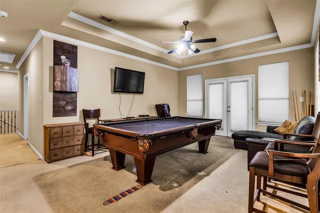 a living room with furniture flat screen tv and a ceiling fan