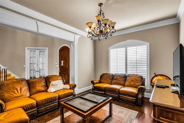 a living room with furniture a chandelier and a window