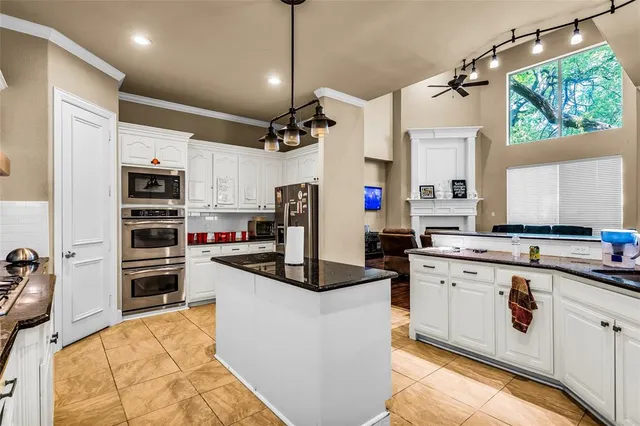 a kitchen with kitchen island a sink stove and refrigerator