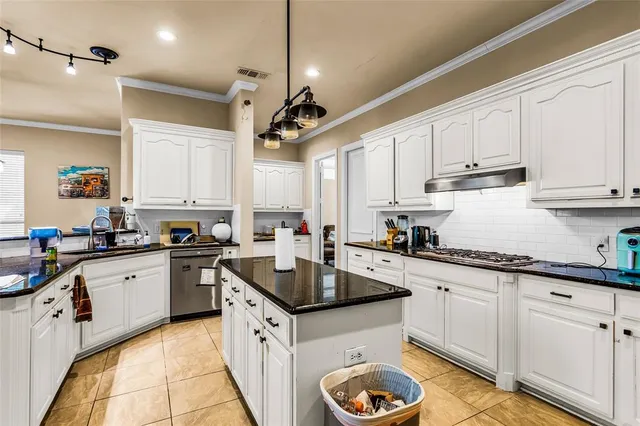 a kitchen with granite countertop a sink a stove and cabinets
