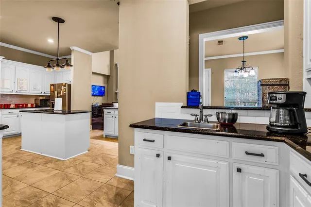 a kitchen with kitchen island granite countertop a sink a counter and cabinets