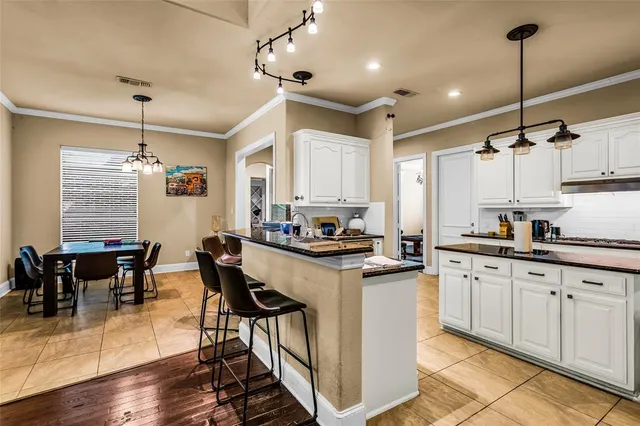 a kitchen with granite countertop white cabinets white appliances dining table and chairs