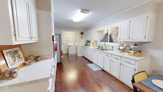 a kitchen with white cabinets and sink