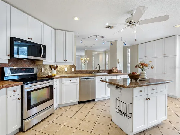 a kitchen with stainless steel appliances granite countertop a stove a sink and a microwave