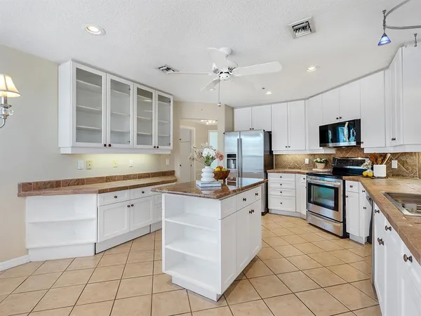 a kitchen with granite countertop white cabinets a sink oven and a counter top space