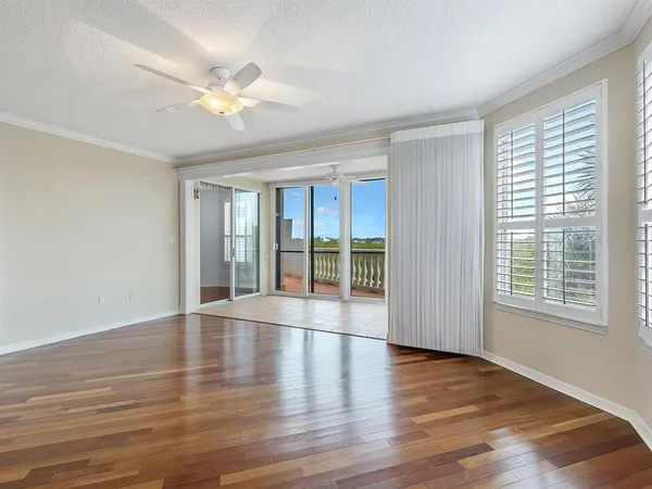a view of an empty room with window and wooden floor