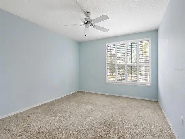 a bedroom with bed mirror and window