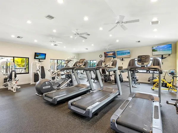 a room with gym equipment and wooden floor