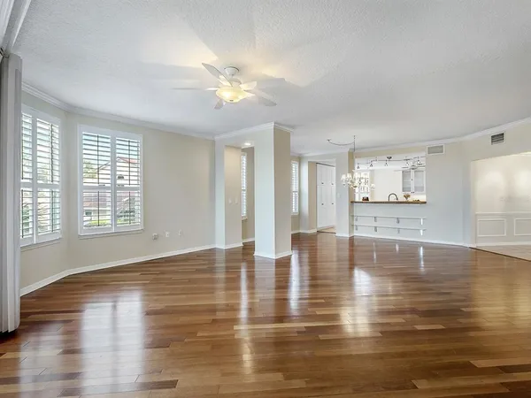 a view of an empty room with window and wooden floor