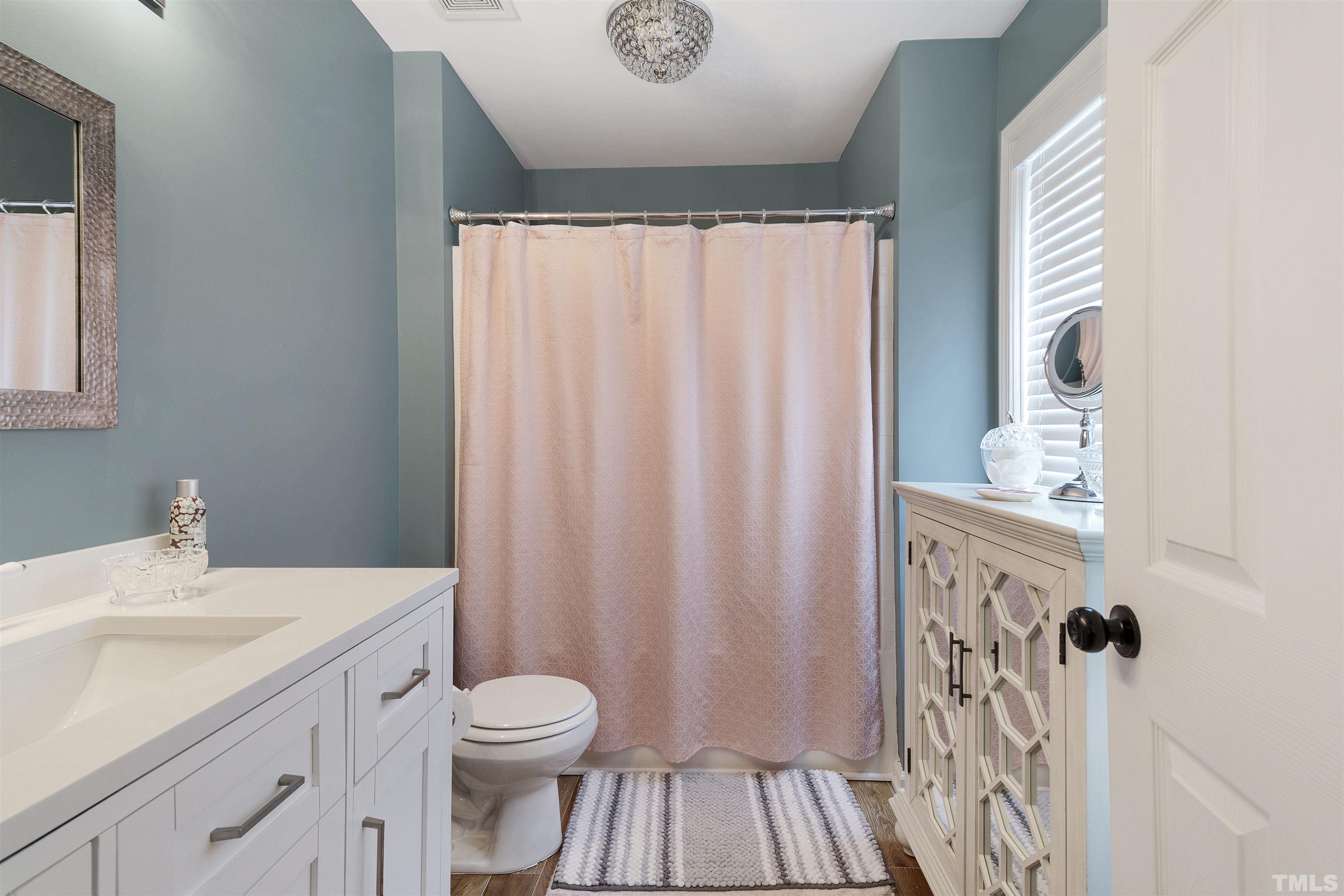 2704 Andover Glen Road Raleigh, NC 27604 - Photo 20 of 30 a bathroom with a sink a toilet and shower curtain