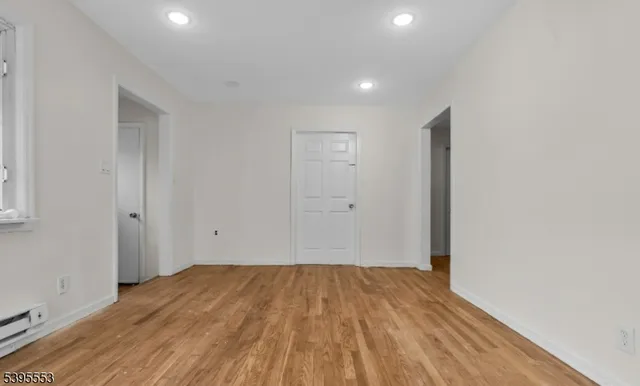a view of a room with wooden floor and white walls