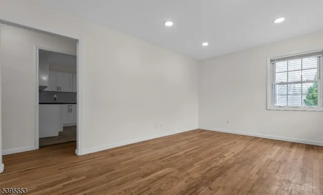 a view of empty room with wooden floor and cabinet