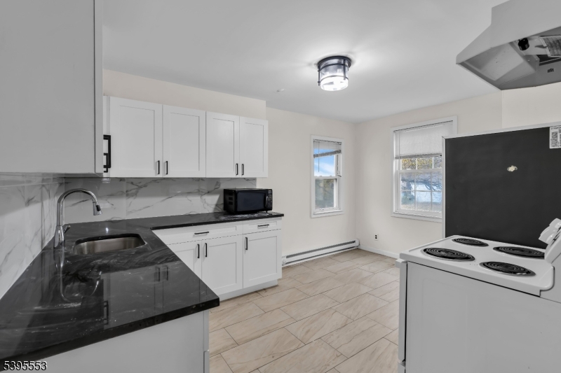 932 Wheatsheaf Road Roselle, NJ 07203 - Photo 16 of 44 a kitchen that has a sink and a stove