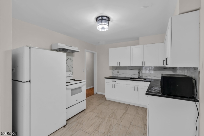 932 Wheatsheaf Road Roselle, NJ 07203 - Photo 18 of 44 a kitchen with granite countertop a refrigerator stove and sink