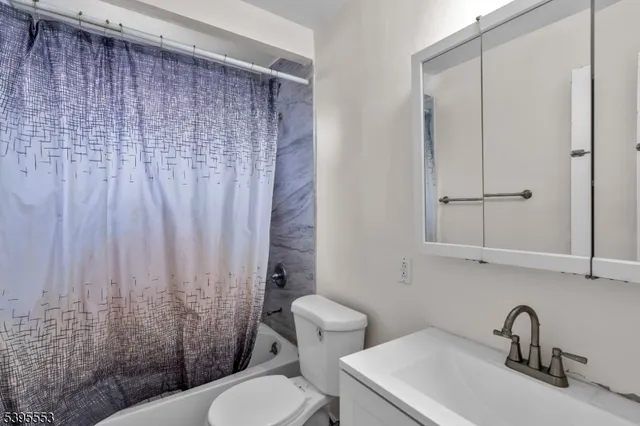 a bathroom with a sink a toilet and shower curtain