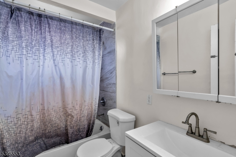932 Wheatsheaf Road Roselle, NJ 07203 - Photo 25 of 44 a bathroom with a sink a toilet and shower curtain