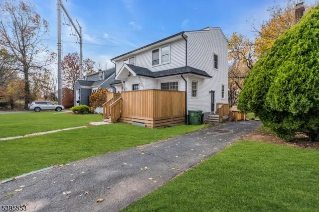 a view of a large house with a big yard and large trees