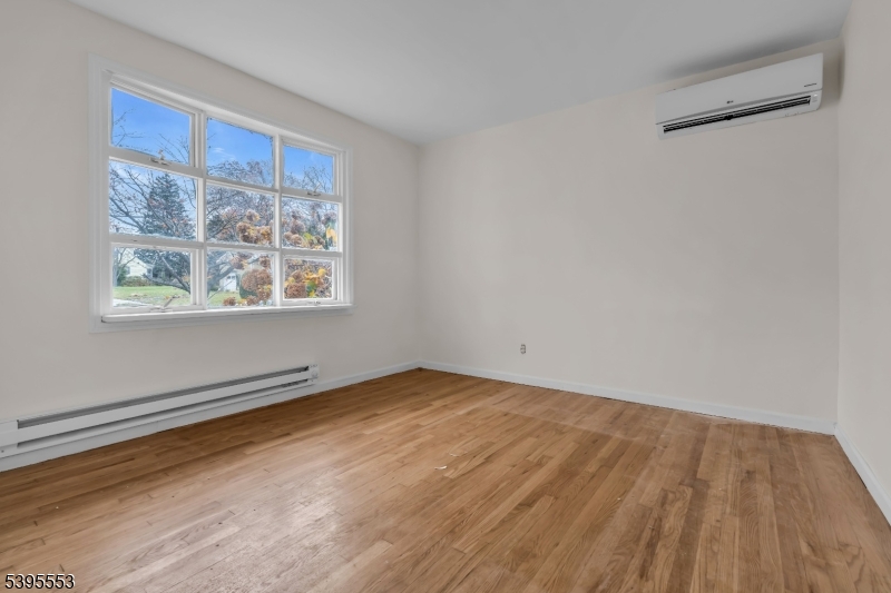 932 Wheatsheaf Road Roselle, NJ 07203 - Photo 10 of 44 a view of an empty room with wooden floor and a window