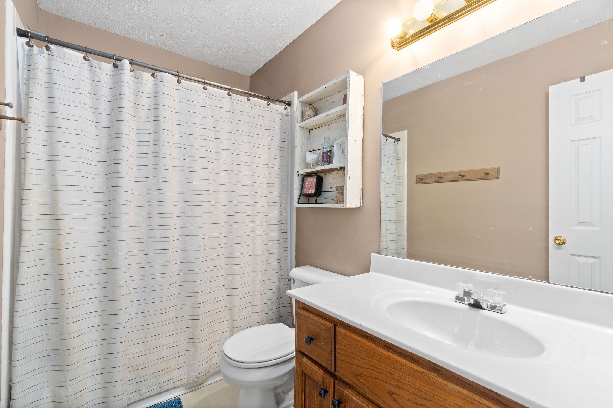 4450 Old Metal Road Palmyra, TN 37142 - Photo 21 of 38 a bathroom with a sink a toilet and shower curtain