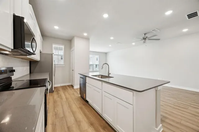 a kitchen with a sink a stove and cabinets
