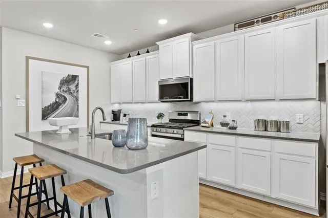 a kitchen with stainless steel appliances granite countertop a sink and a stove