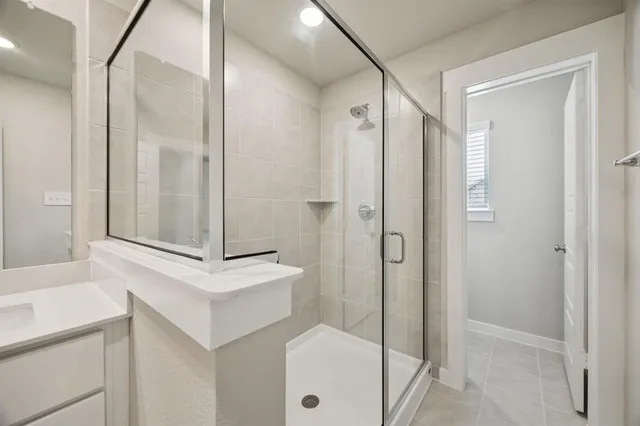 a bathroom with double vanity sink a mirror and shower