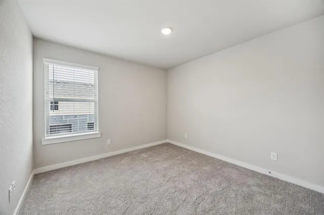 a bedroom with a bed large window and lamp