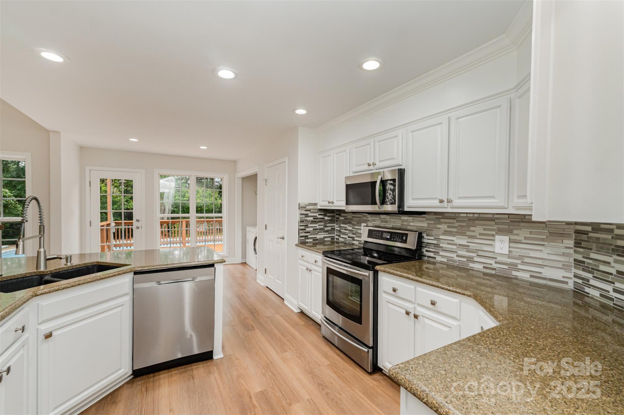 125 Stumpy Creek Road Mooresville, NC 28117 - Photo 5 of 23 a kitchen with stainless steel appliances granite countertop a stove a sink and a microwave