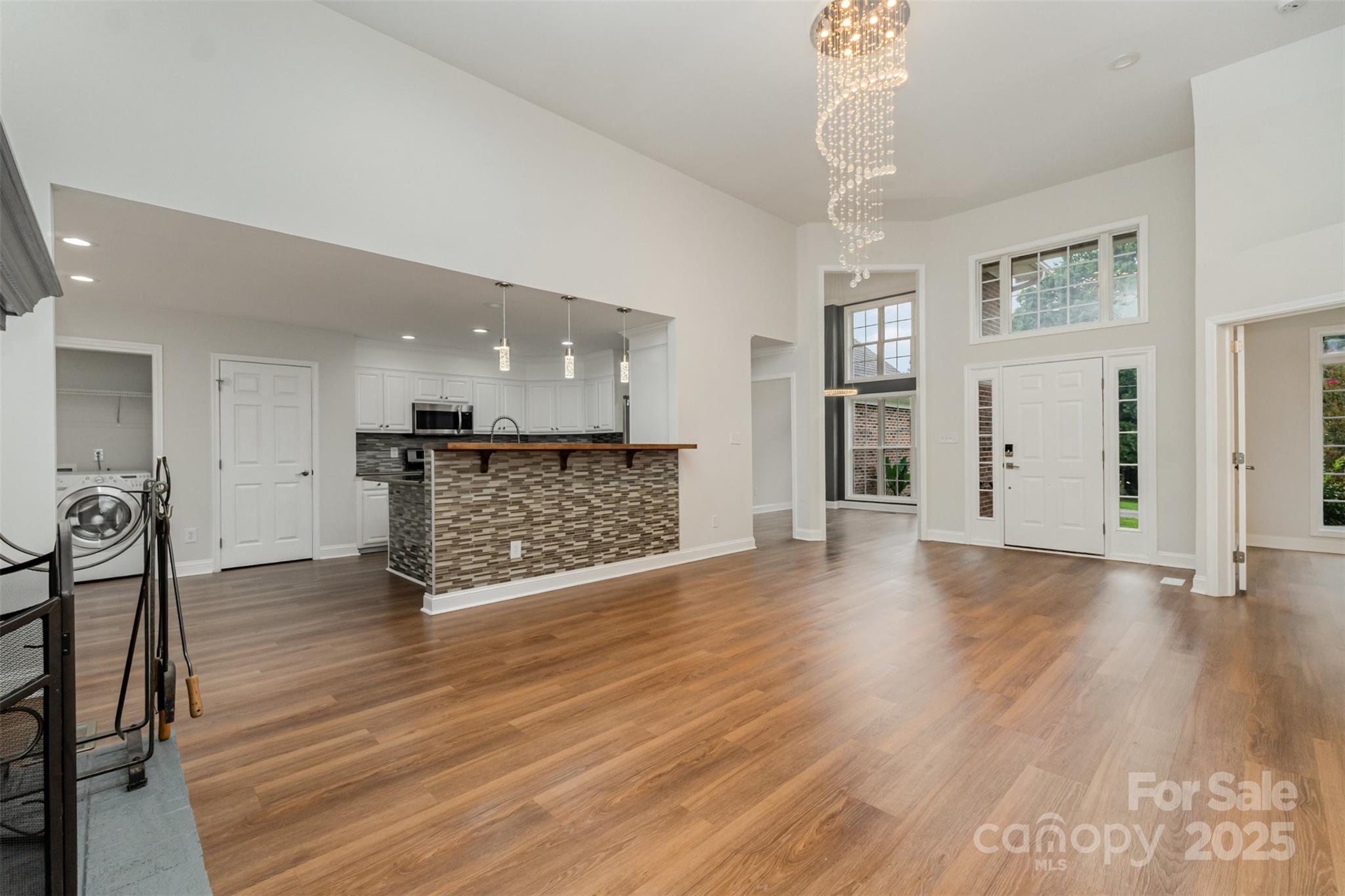 125 Stumpy Creek Road Mooresville, NC 28117 - Photo 7 of 23 a view of an empty room with wooden floor and a kitchen