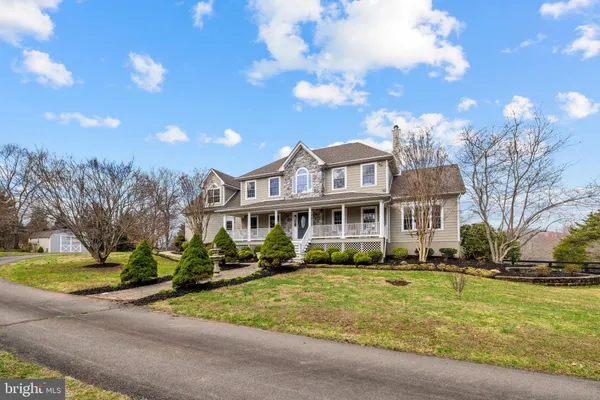 a front view of a house with a yard and potted plants